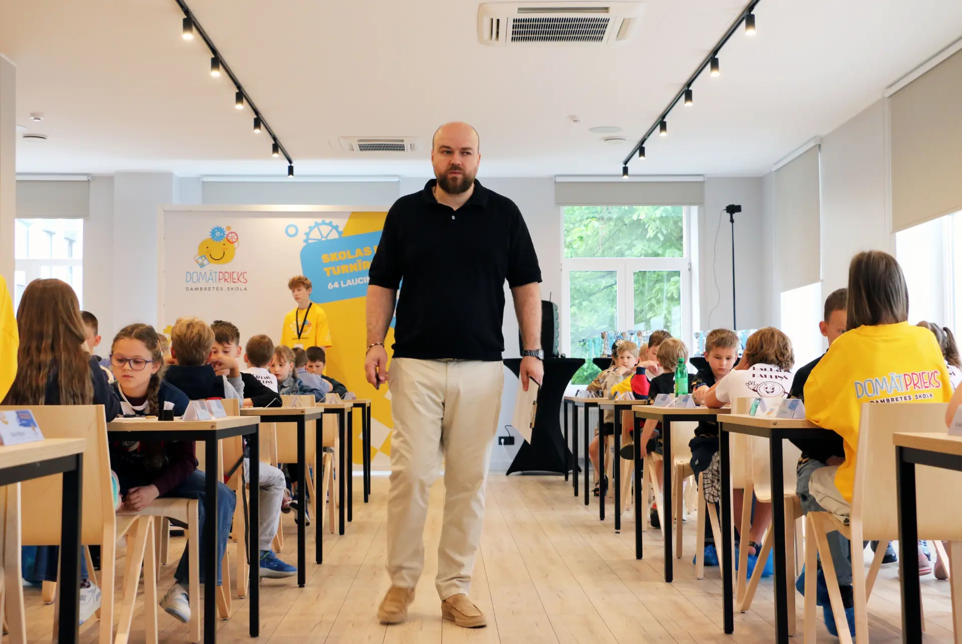 Dambretes turnīrs Lielajā zālē ar dalībnieku galdiem